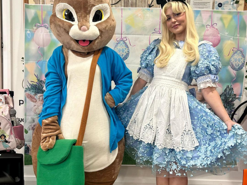 A person dressed in an Easter Bunny costume stood next to a lady dressed as Alice in Wonderland
