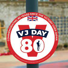 A round VJ Day 80 poster attached to a post