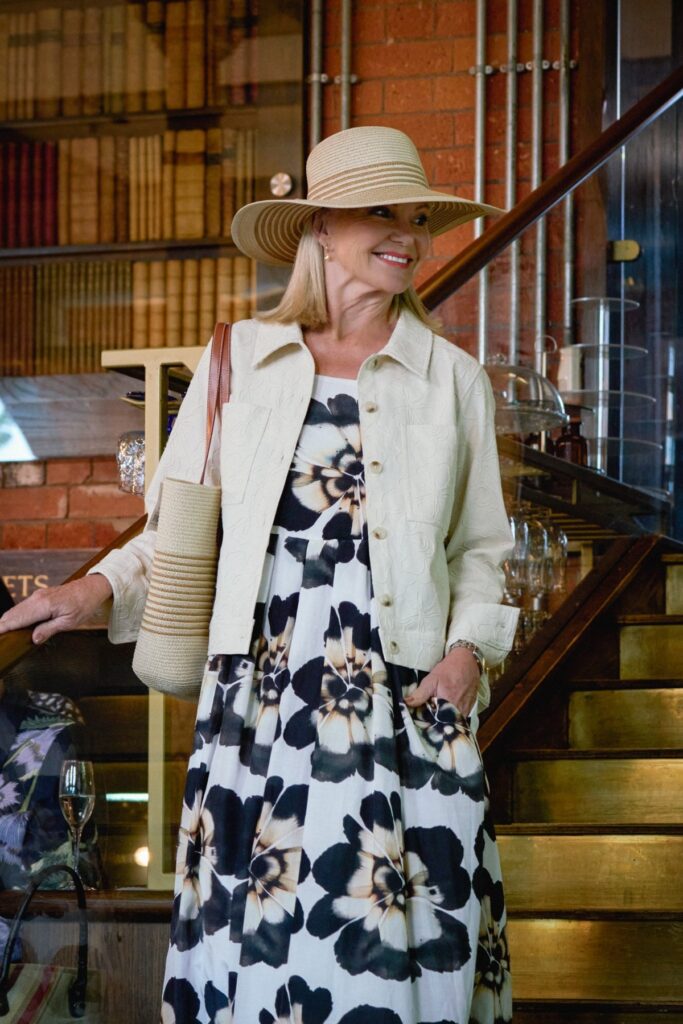 woman modelling dress with jacket, sun hat and bag